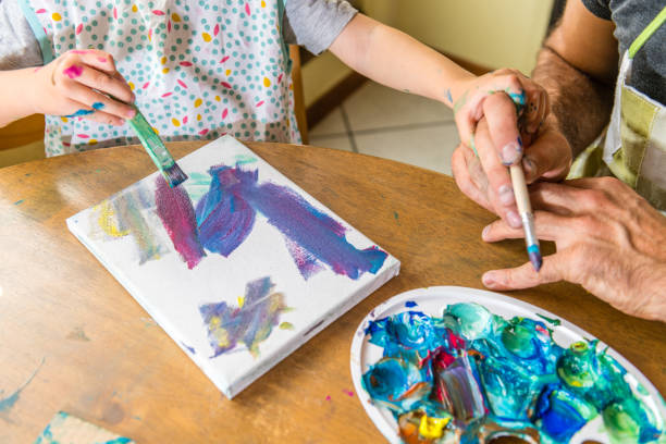 istock Father and son painting together 1143964533
