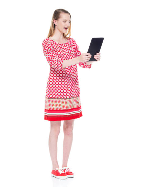 istock Beautiful young white female wearing red dress - using tablet 1143964748