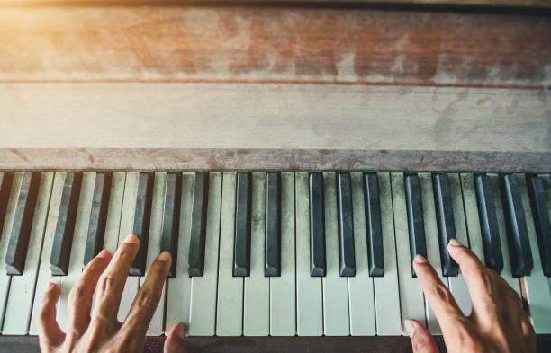 istock Man's hands playing the Piano. Retro Style. Warm color tones. 1143964880