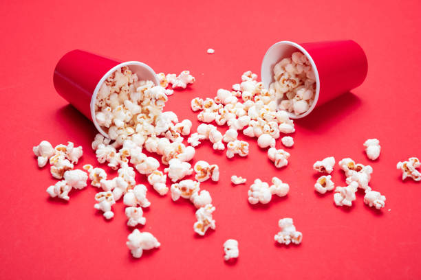 istock Pop corn scattered on red color background, closeup view 1143972542