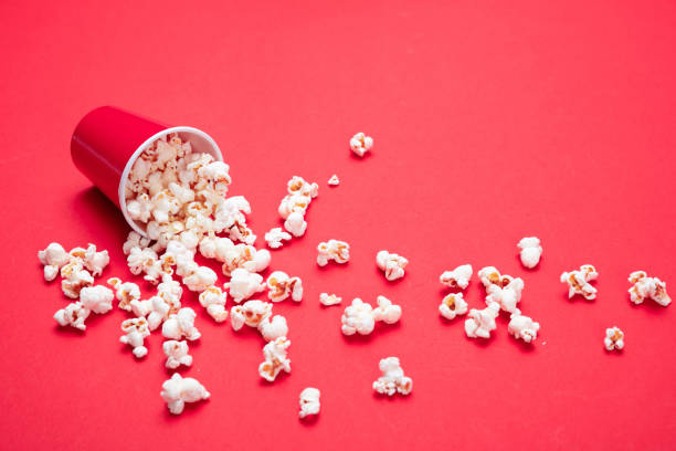istock Pop corn scattered on red color background, closeup view 1143972543