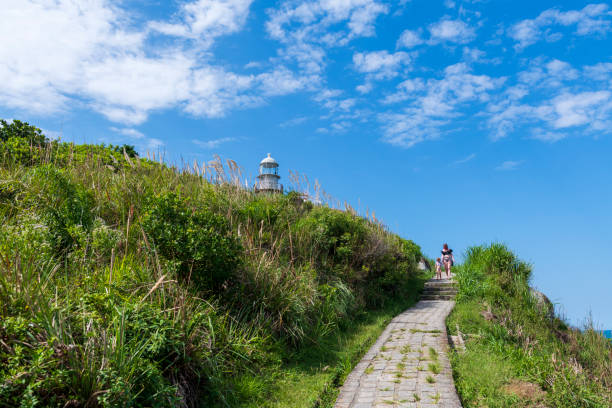 A mother walks with her young daughter down the hill after visiting Farol das Conchas (lighthouse of the shells), built on the Brazilian island of Ilha do Mel in 1872 to guide ships in Paranaguá Bay. (April 3, 2019)