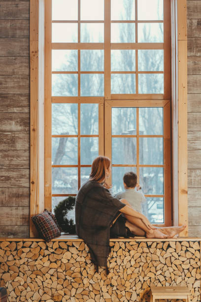 istock Mom and son sitting on the windowsill and playing. 1143976399