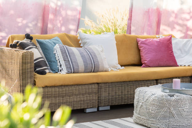настоящая фотография разноцветных подушек на ротанговом диване на террасе - cushion стоковые фото и изображения