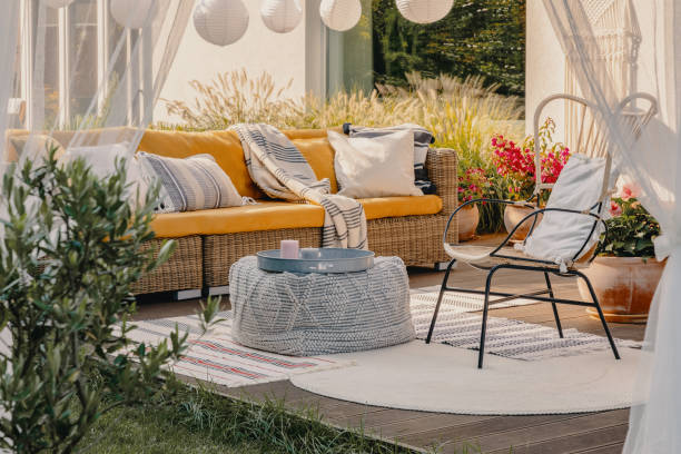 real photo of an armchair, pouf as a table and wicker couch on a terrace - artigo de decoração imagens e fotografias de stock