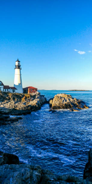 istock beautiful blue lake in maine with lighthouse 1143981422