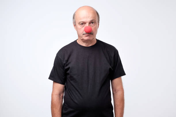 mature businessman wearing clown nose isolated on white background - clowns nose imagens e fotografias de stock