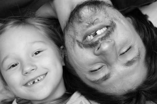 Funny portrait of father and daughter without a tooth, in B&W