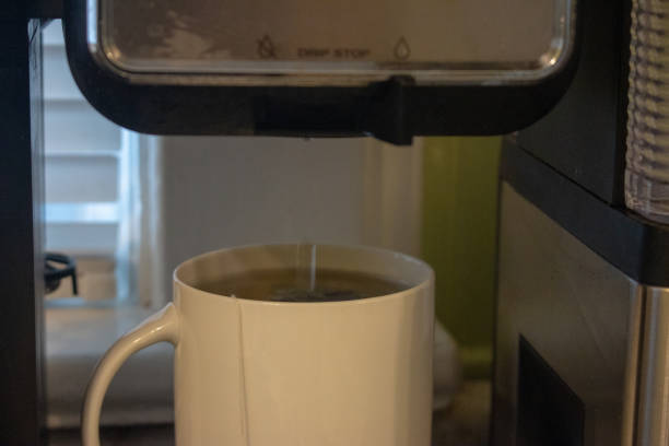 istock Pouring hot water into into a cup on a black background. 1143983719