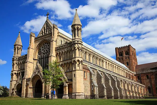 St Albans Cathedral in St Albans, Hertfordshire, England with a blue sky and some clouds. Although of a Norman structure the Cathedral's origins date back to Anglo Saxon times and is the longest cathedral in England