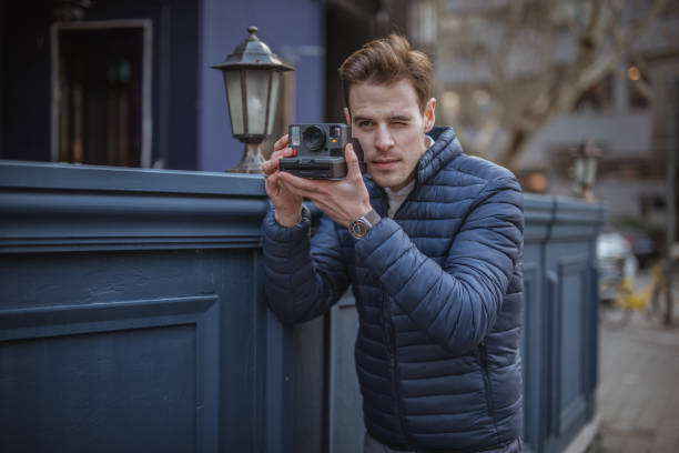 istock Man photographing with instant camera 1143984027
