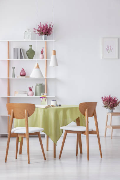 istock Chairs at table in elegant dining room with heather in pots and accessories on shelf , real photo 1143984751