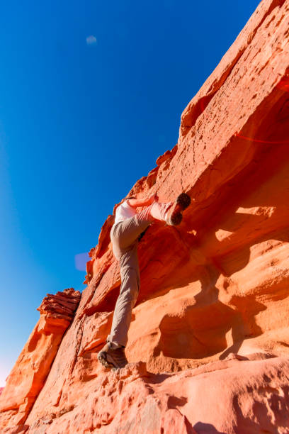 ワディ・ラムの岩を上に移動する女性クライマー - mountain climbing pursuit women sunset ストックフォトと画像