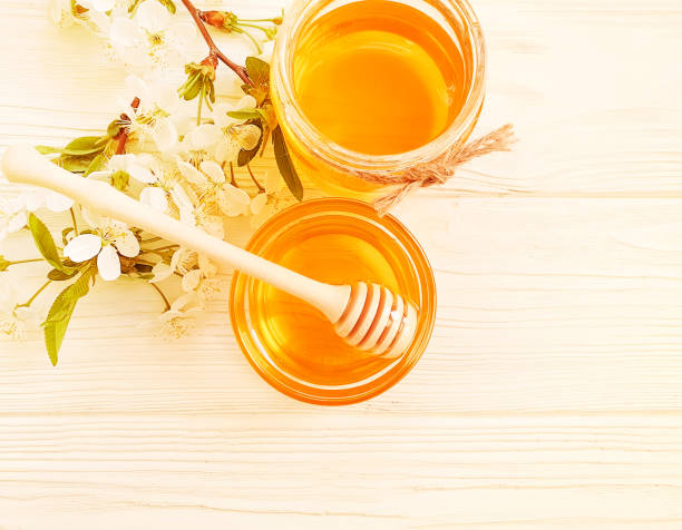 istock honey, cherry blossoms on a wooden background 1143987714