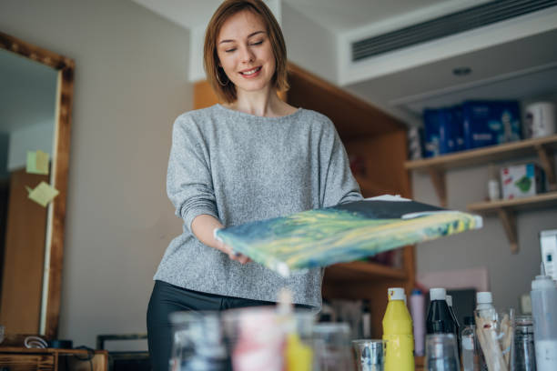 istock Pretty woman painting on canvas 1143988112