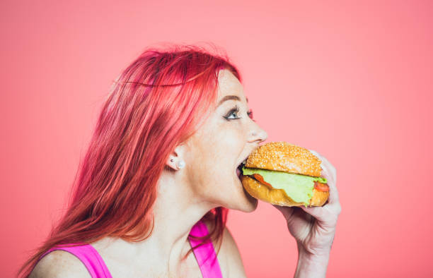 istock Girl Eating a Hamburger 1143989098