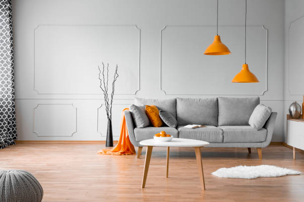 istock Copy space on empty grey wall of elegant orange and grey living room interior 1143990728