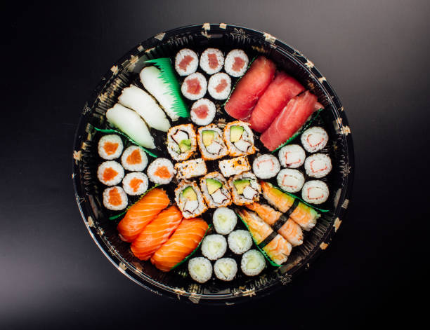istock Sushi Set sashimi and sushi rolls served on plastic plate and dark background 1143991718