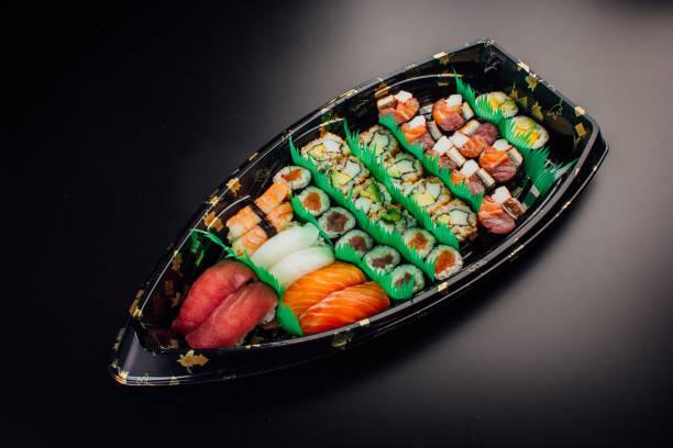 istock Japanese cuisine. Sushi set on a plastic ship over dark background. 1143991746