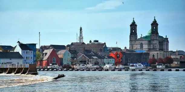 The town of Athlone in the midlands of Ireland on the banks of the river Shannon with the weir wall, boats and the church in site