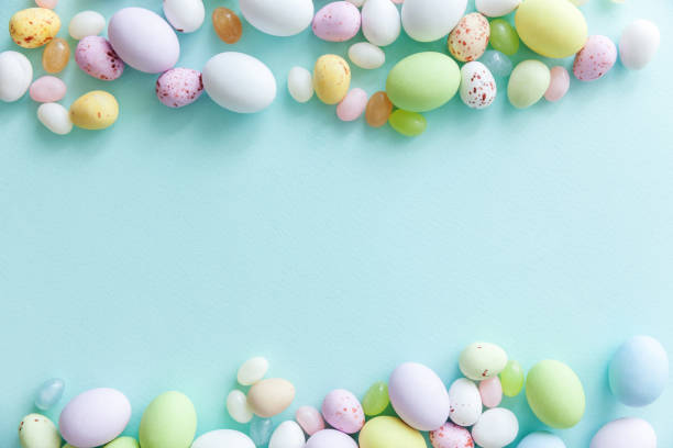 istock Happy Easter concept. Easter candy chocolate eggs and jellybean sweets isolated on trendy pastel blue background. Simple minimalism flat lay top view copy space 1143997176