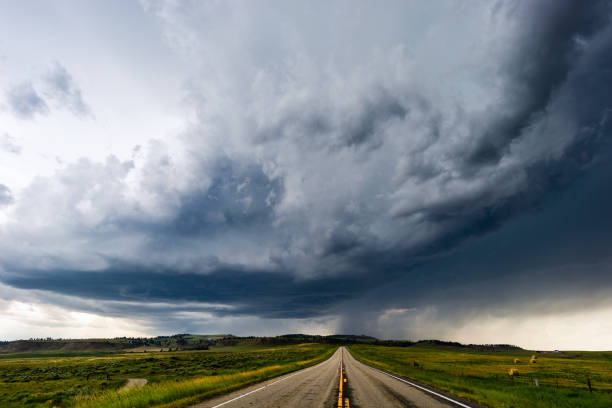 istock Straight road leading to dark storm clouds 1143998117