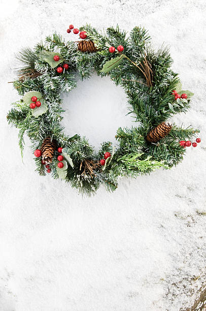 istock Pine cone and Berry wreath against snowy wall 114399826