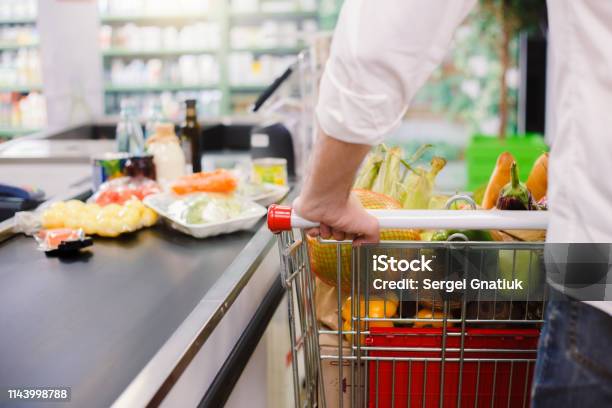 Man Kauft Lebensmittel Im Supermarkt Stockfoto und mehr Bilder von Supermarkt - Supermarkt, Theke, Einkaufswagen
