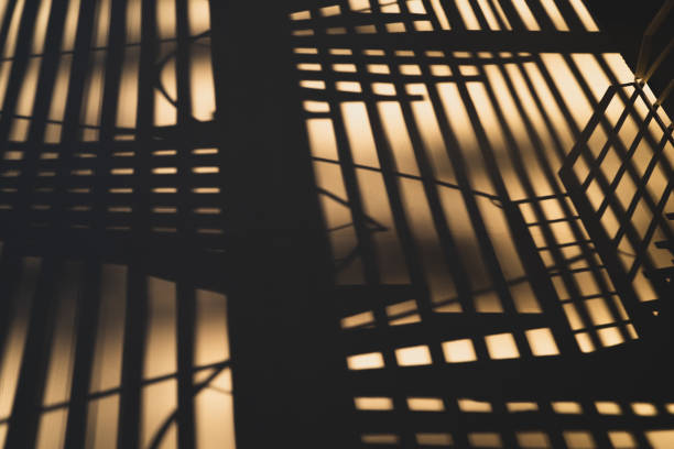 Shadow of a spiral steel fire escape staircase cast upon a rendered concrete wall.  Palma Nova, Mallorca, Spain.