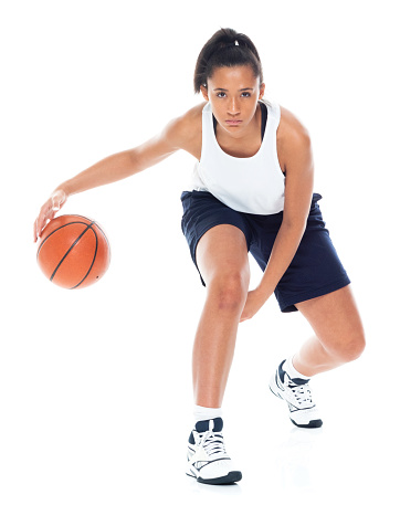 Attractive African American female playing basketball