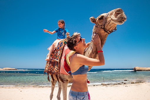 Daughter and Mother Enjoying Using a Camel on Vacations in Egypt.