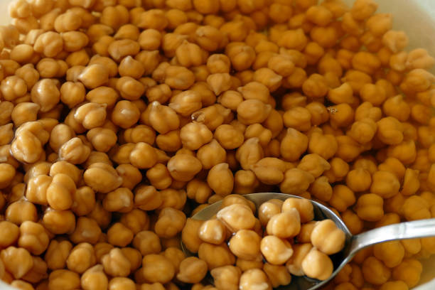 Wooden bowl with chickpeas on table