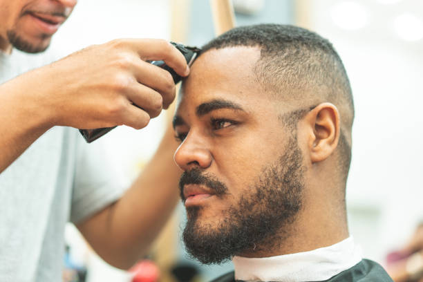 istock Hairdresser using hair clipper on your client 1144014363