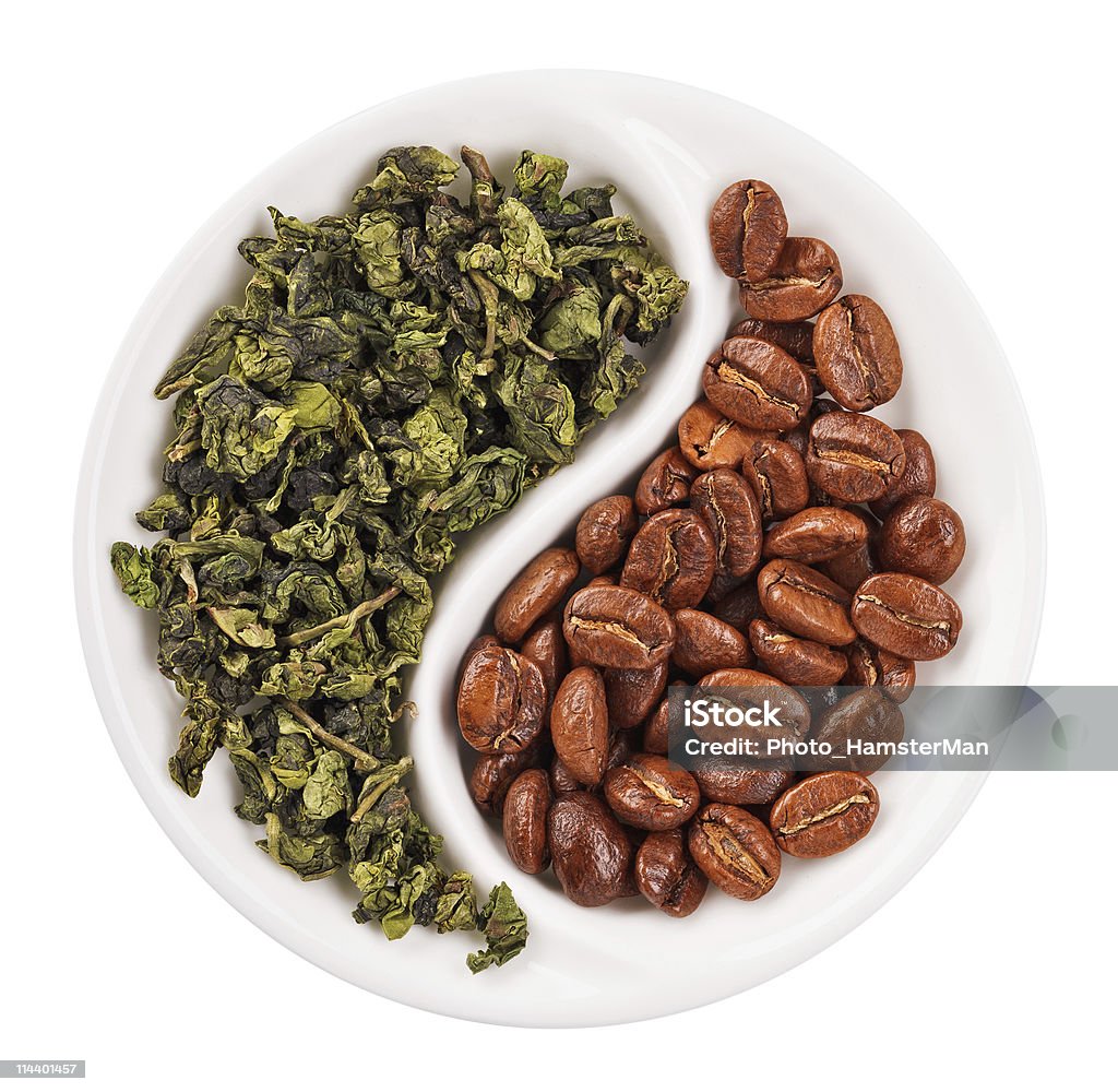 Hojas de té verde en comparación con granos de café en el plato de Yin Yang - Foto de stock de Café - Cultivo libre de derechos