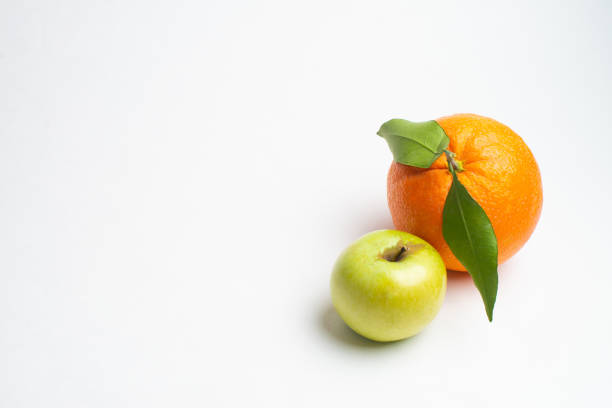 mele e arancia fresca dal giardino sfondo bianco isolato - comparison apple orange isolated foto e immagini stock