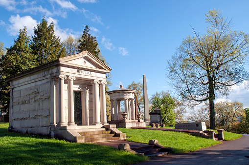 Pittsburgh, Pennsylvania, USA 04/20/2019 The Hemphill and Baum family mausoleums next to a road in the Homewood Cemetery on a bright spring day