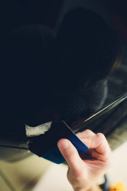 istock Worker hands installs car paint protection film 1144034796