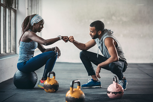 Trainer and female client talking in gym