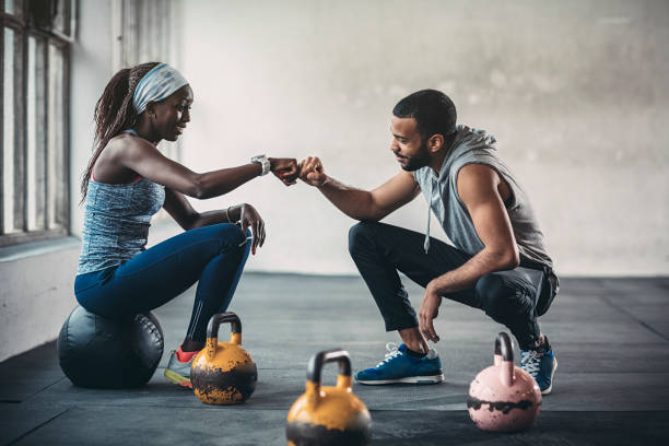 Trainer and female client talking in gym stock photo