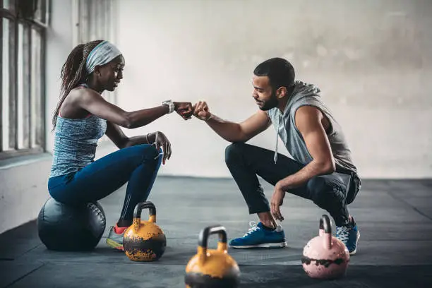 Photo of Trainer and female client talking in gym