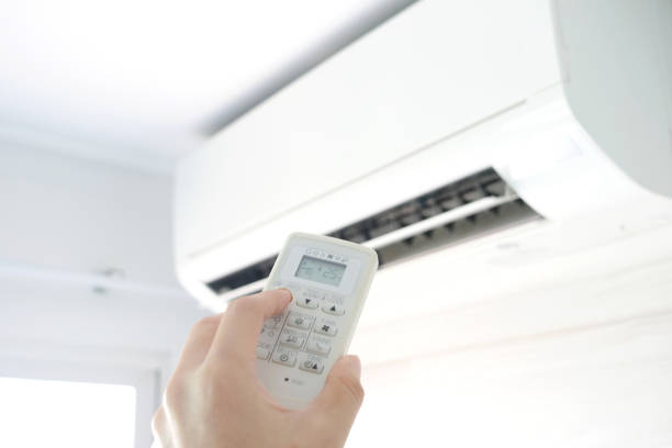 istock Man's hand using remote control open The air conditioner is cooled to 25 degrees Celsius in his bedroom. Health concepts and energy savings 1144049335