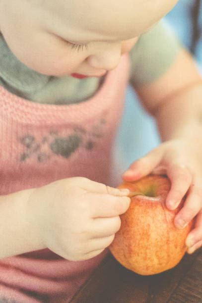 Body part Pregnant belly and hand holding green apple with white dress Selective focus