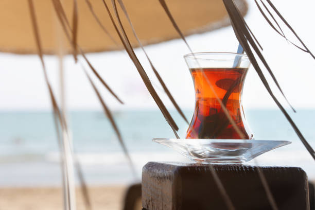 été, un verre de thé, sur la plage, sur le fond de la mer. le concept des vacances d’été et des vacances. - at the beach photos et images de collection