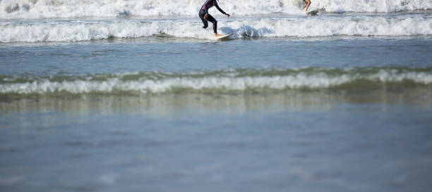 istock Two surfers riding waves in the ocean 1144071176