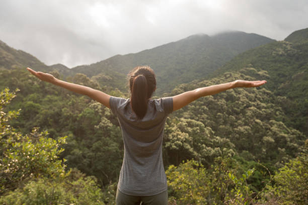 istock young woman open arms at spring forest mountain top 1144072644