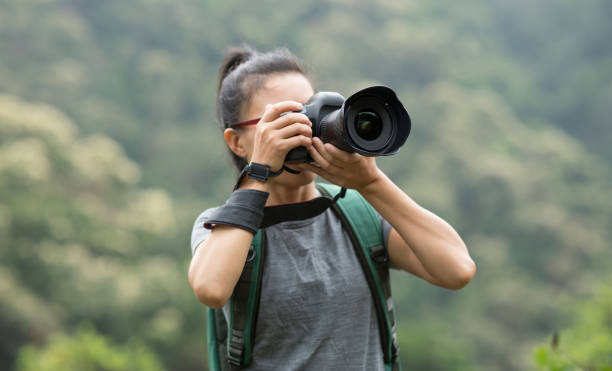 istock woman photographer taking photo on spring forest mountain 1144074792