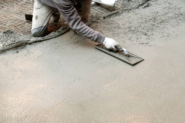 istock Worker flattening cement mortar on floor 1144078097