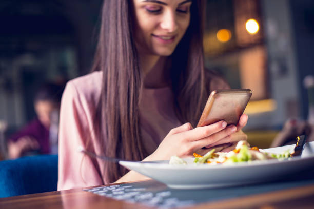 istock Young teenage girl checking her phone while having lunch 1144080719