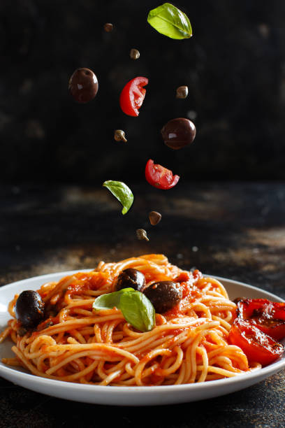 espaguetis con aceitunas de salsa de tomate y alcaparras - comida italiana fotos fotografías e imágenes de stock