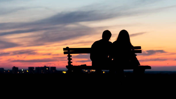 istock Couple sitting on the bench above horizon 1144085021